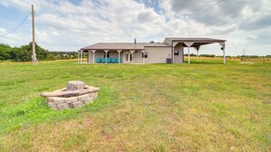 A two-story building with a covered porch and a fire pit in the foreground. - Peaceful Vinita Home w/ Fire Pit: 11 Mi to Lake! (Vinita)