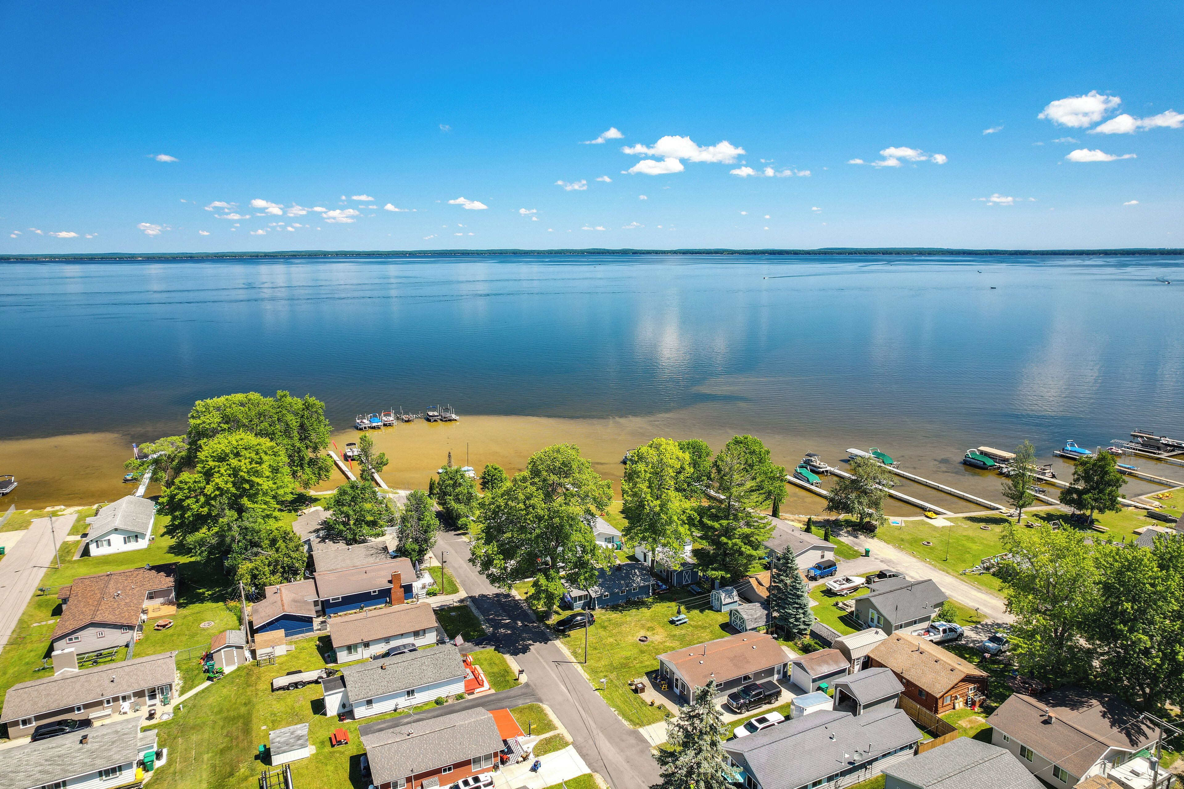A residential area with houses, a dock, and a calm lake.