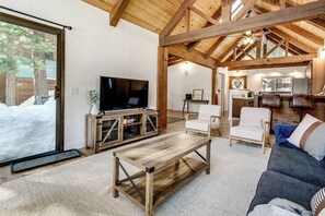 A cozy living room with a wooden coffee table, a sofa, and a TV on a wooden cabinet. - Bright Truckee Cabin Close to Skiing & Donner Lake (Truckee)