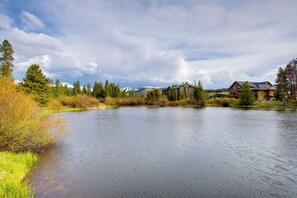 A lake with a wooden cabin and a mountain in the background. - Hike, Bike, Ski: Winter Park Condo w/ Deck (Winter Park)