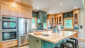 Una cocina moderna con electrodomésticos integrados, una isla grande y vistas al exterior.