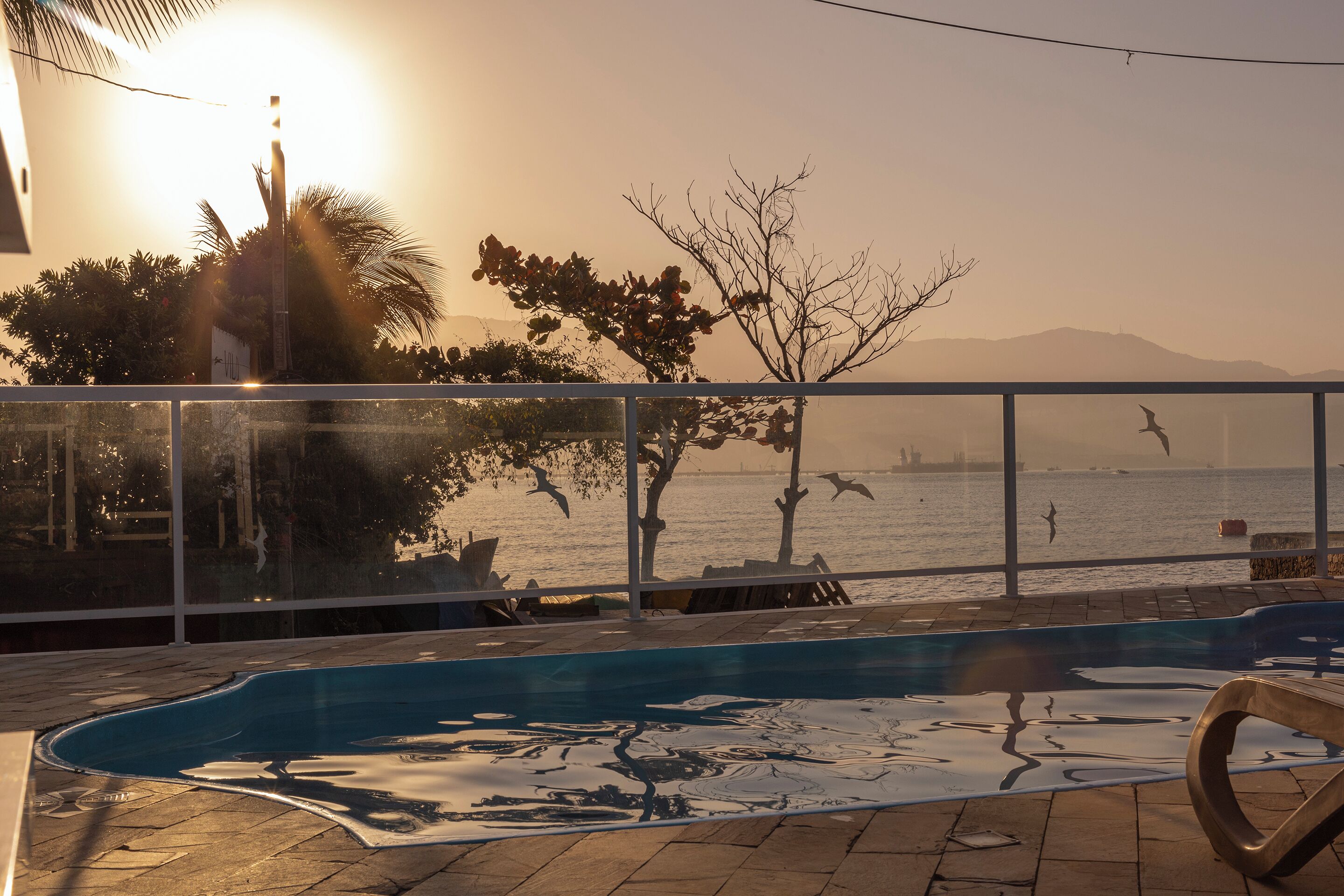 Une piscine avec vue sur la mer et les montagnes en arrière-plan.
