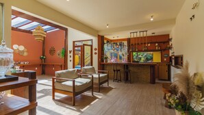Un amplio salón con cocina, muebles de madera y una zona de bar.