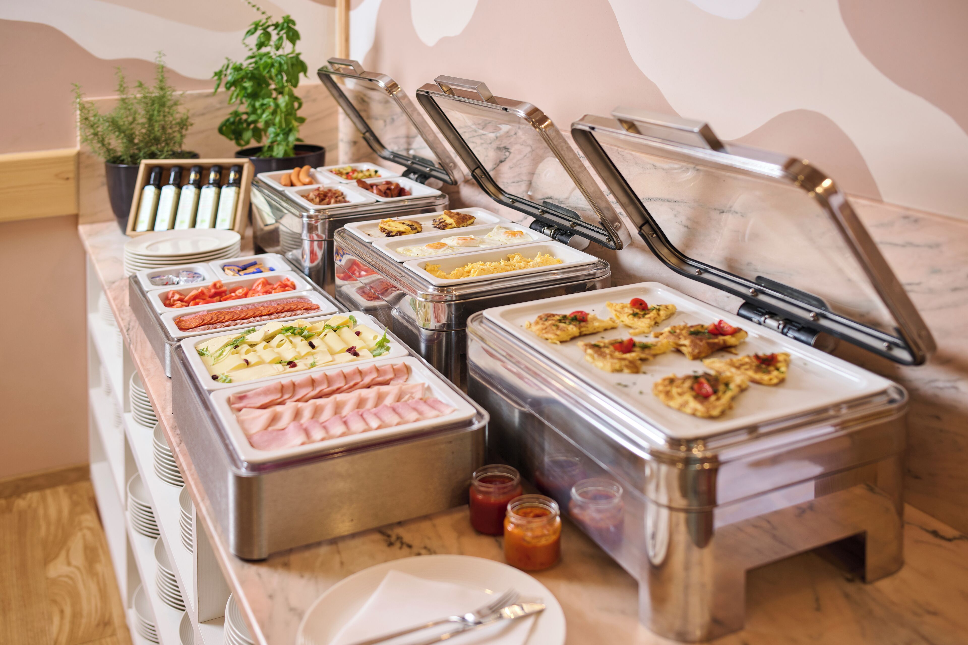 A buffet with various food items in clear containers, including meats, cheeses, and salads.