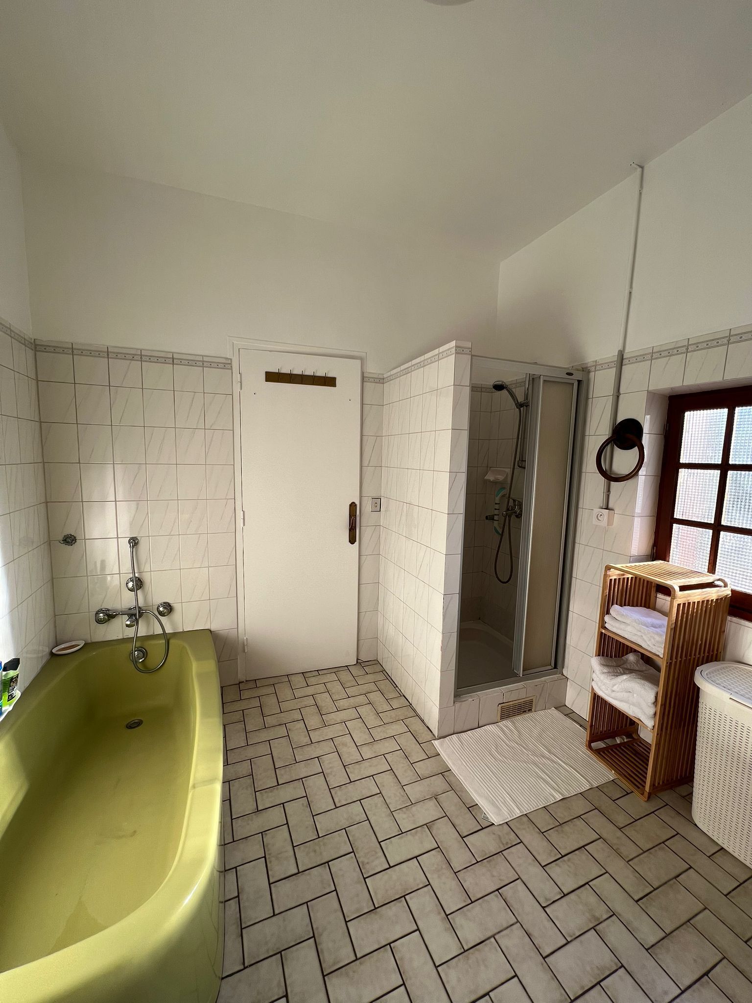 Ein Badezimmer mit einer großen Badewanne, einer Duschkabine und einem Holzboden mit Handtüchern.