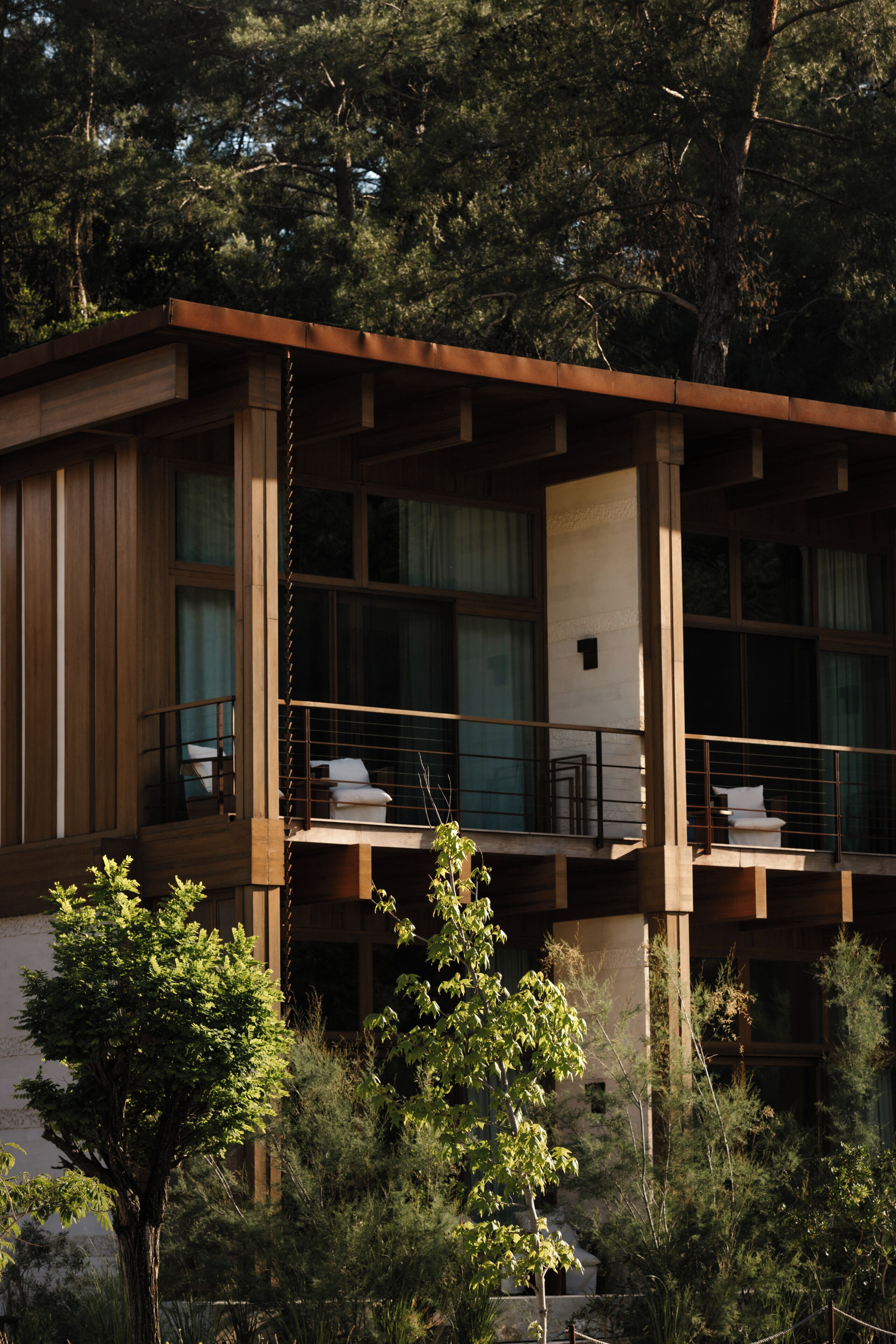 A modern building with a balcony, large windows, and a wooden facade.