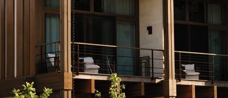 A modern building with a balcony, large windows, and a wooden facade.