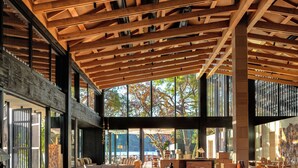 A spacious interior with a high ceiling, large windows, and a mix of seating areas. - Ahama - Relais & Châteaux (Fethiye)