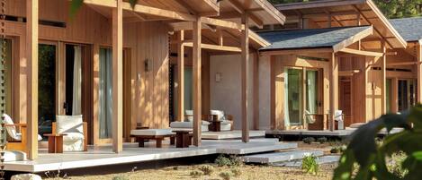 A wooden cabin with multiple rooms, each with a balcony and seating area.