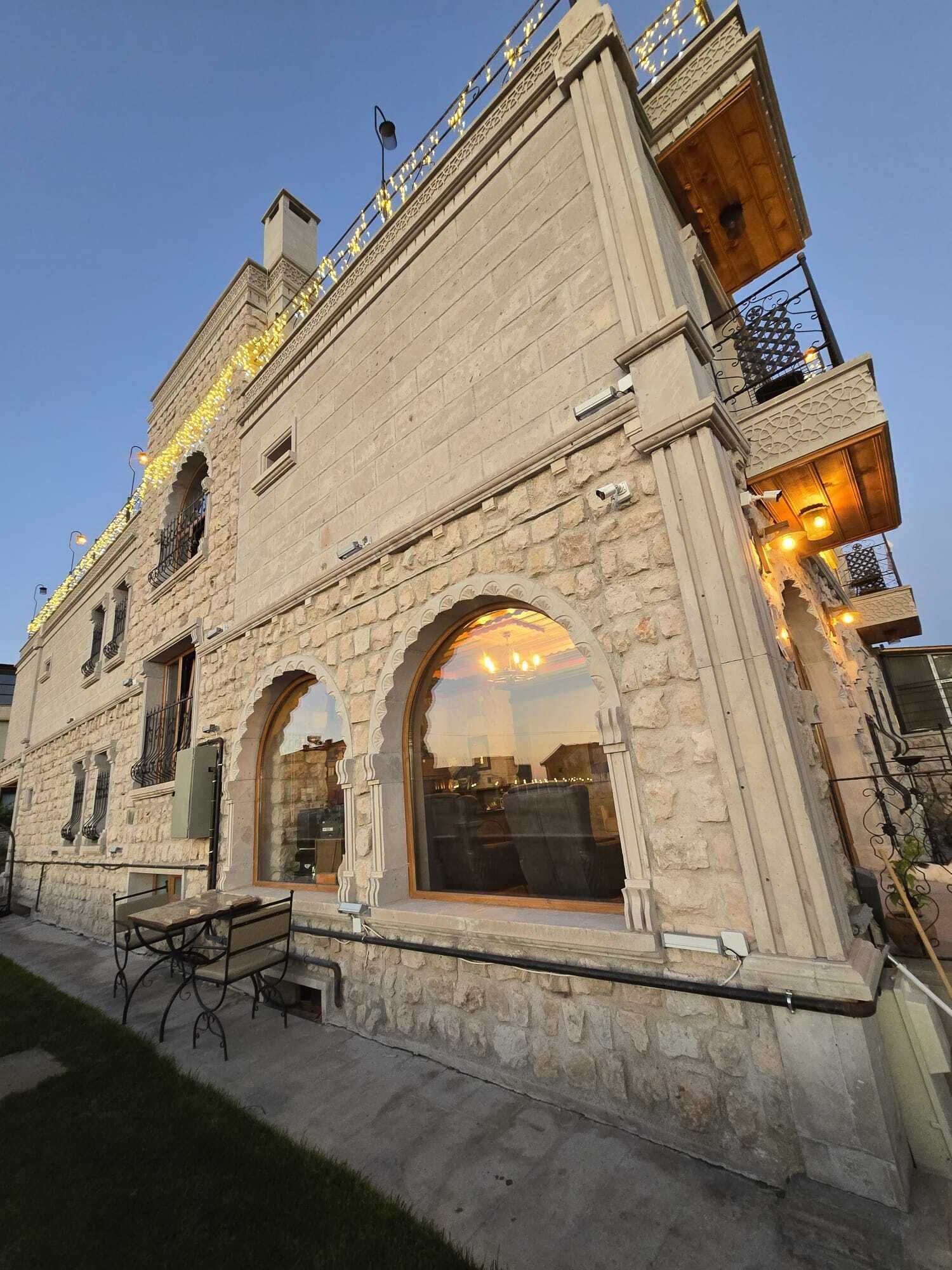 A stone building with arched windows and a balcony.