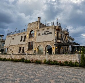 A stone building with the name 'Cappadocia ELITE ROSE' on the facade, featuring arched windows and a balcony. - Elite Rose (Nevsehir)