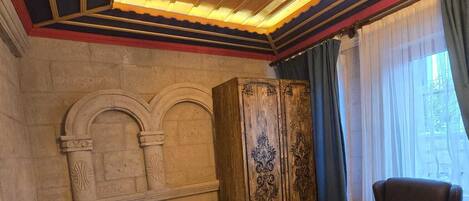 Un baño con una bañera independiente, una pared de piedra y un tocador de madera.