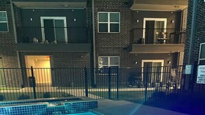 A swimming pool with a metal ladder and a tiled border. - Your Cozy & Captivating Condo! (Houston)