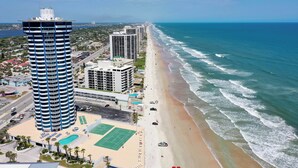 A coastal hotel with a prominent tower, beachfront access, and a tennis court. - Beautiful Oceanfront 2BDR/2BA @ Peck Plaza 5SE (Daytona Beach)