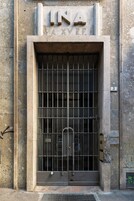 A large, barred entrance with a sign above reading "INA".