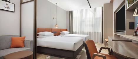 A modern hotel room with a bed, a sofa, a desk, and a TV.