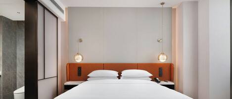 A modern hotel room with a large bed, two bedside tables, a nightstand, a wall-mounted control panel, and a large window.