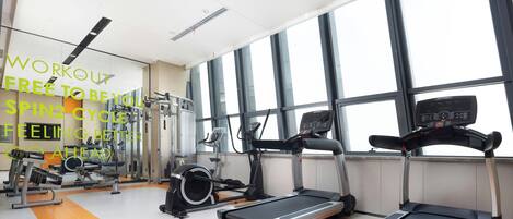 A gym with treadmills, exercise bikes, and weight machines.