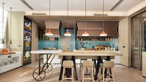 Une cuisine moderne dotée d’un îlot central, de luminaires suspendus et d’une grande fenêtre.