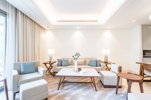 Relax in this inviting living room with a large sofa, coffee table, and side tables, perfect for unwinding.