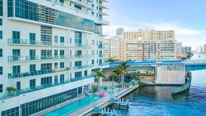 A high-rise hotel with a rooftop pool, waterfront views, and a bridge in the background. - Awesome Bayview Pools Gym (Hollywood)