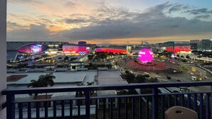 A cityscape at dusk with illuminated buildings and a prominent pink spherical structure. - Family/Barkada Room 6-10 pax Mall of Asia view Sea Residences  (Pasay)