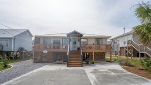 A two-story building with a central staircase, a balcony, and a porch area.