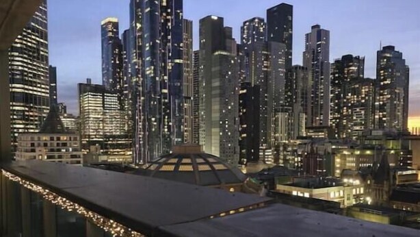 Vista panorámica de la ciudad desde un edificio alto, con cielo despejado.