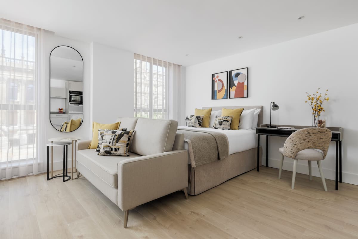 A modern bedroom with a sofa, a desk, and a chair.