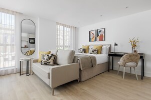 A modern bedroom with a sofa, a desk, and a chair.