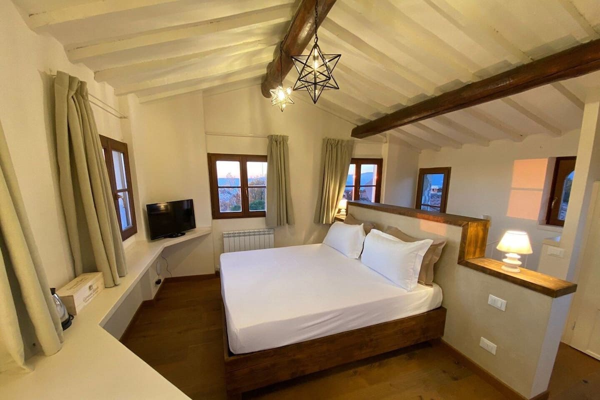 Ein Schlafzimmer mit einem hölzernen Bett, einem Fernseher auf einem Regal und einer sternförmigen Leuchte.