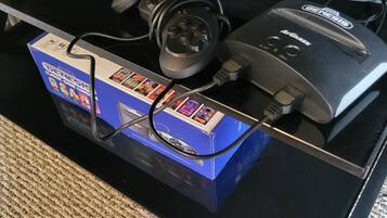 A black table with a blue box labeled "GENESIS" and a black device with a cord plugged into it.