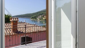 A balcony with a view of a body of water and a hillside. - Villa Oliva Vilea in Sveta Marina  - Haus für 8 Personen (Labin)