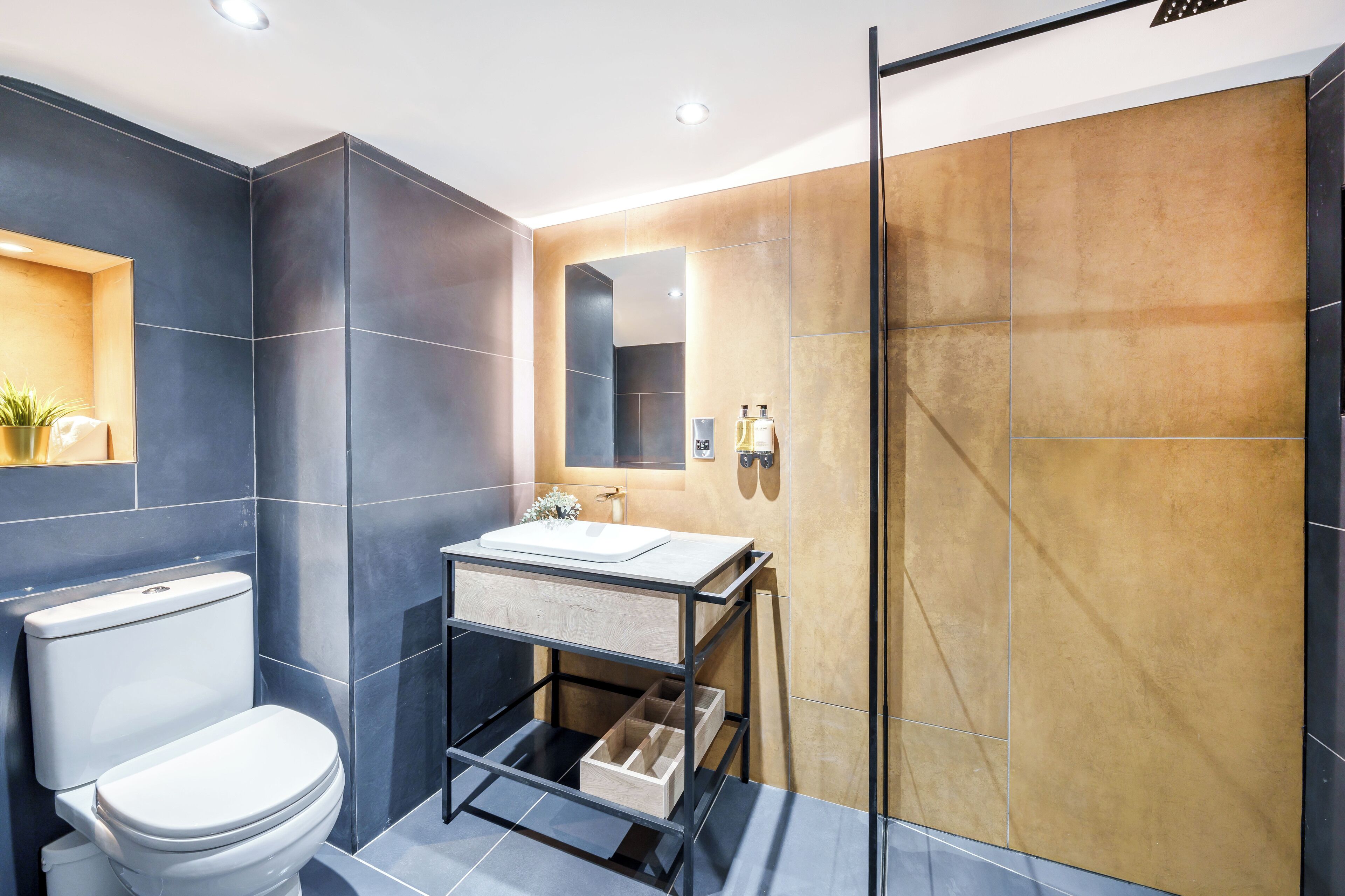 A modern bathroom with a toilet, sink, and shower.
