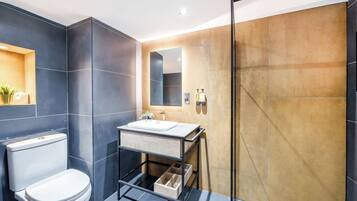A modern bathroom with a toilet, sink, and shower.