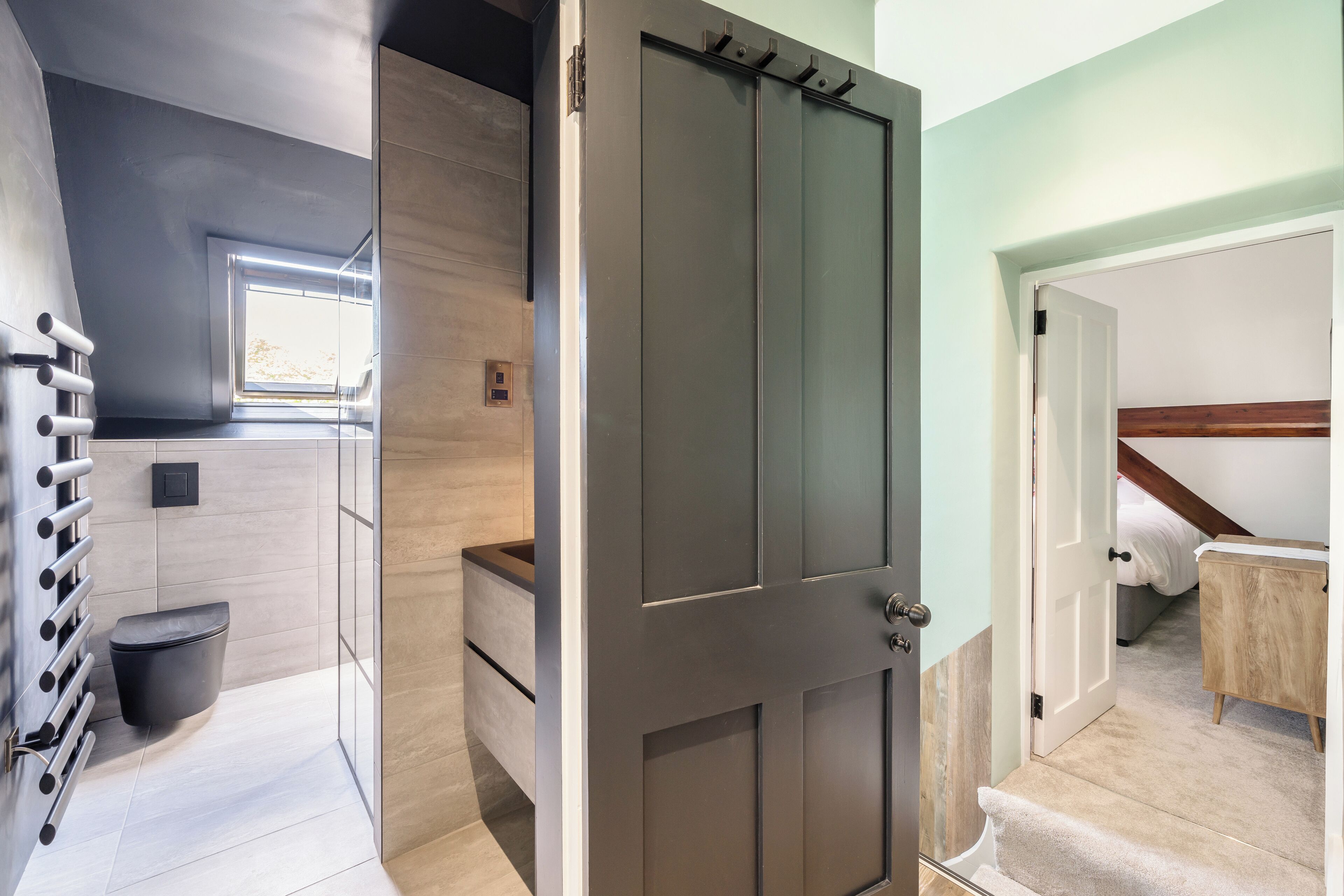 A modern bathroom with a toilet, sink, and shower area.