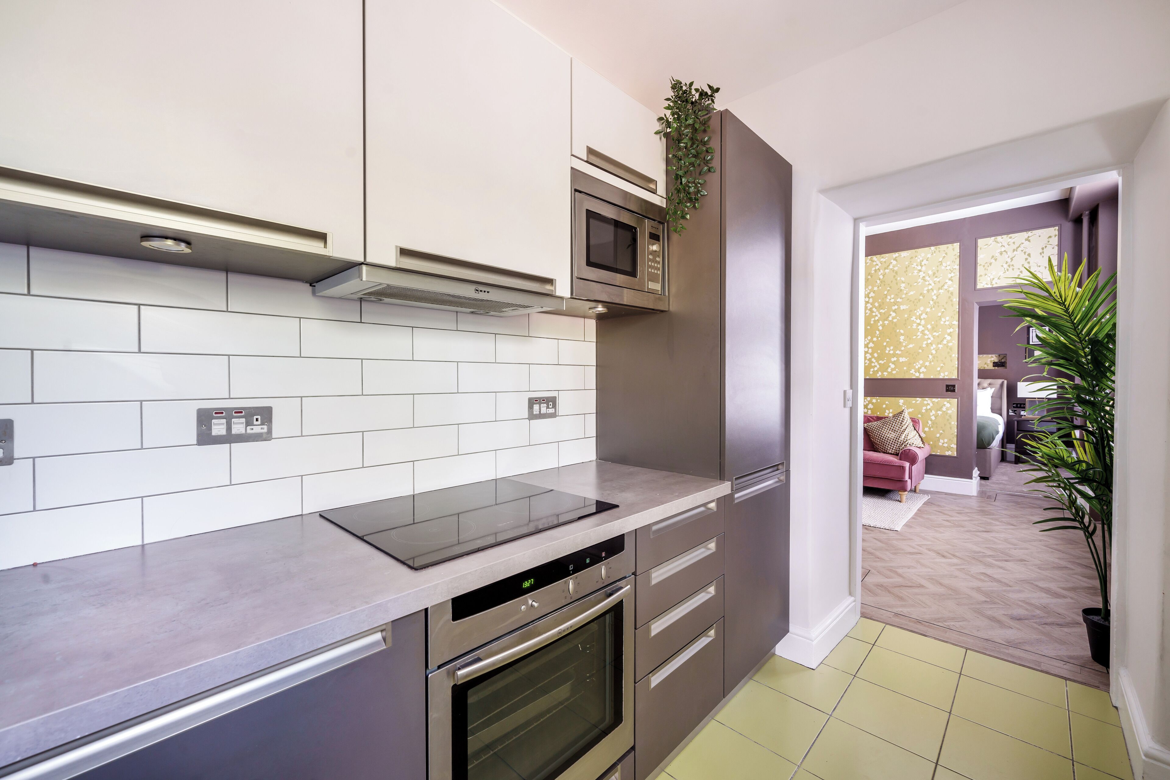 A modern kitchen with stainless steel appliances, a built-in microwave, and a grey countertop.