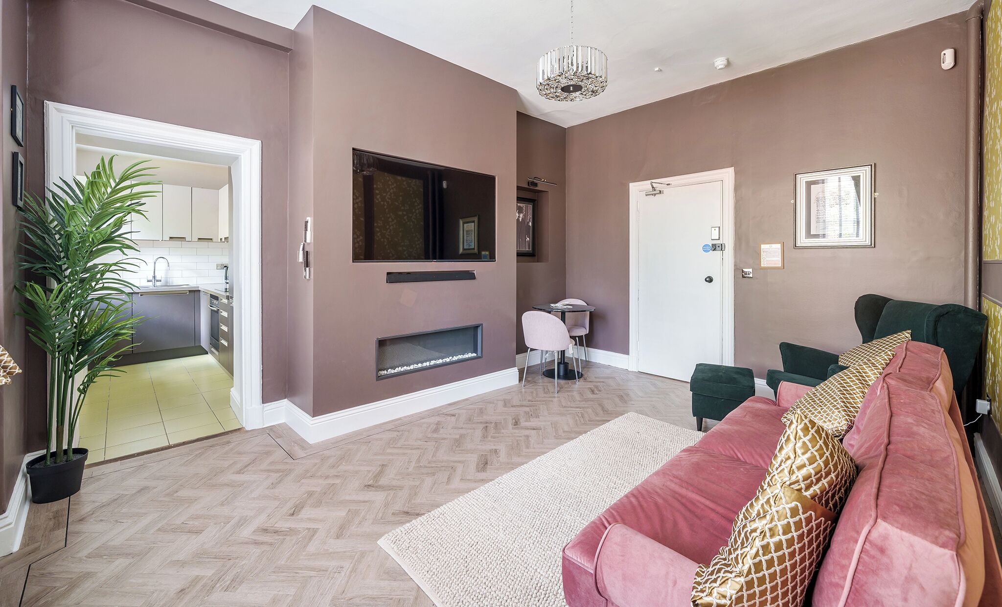 A modern living room with a fireplace, a sofa, and a dining area.