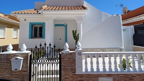 A white building with a tiled roof, a mailbox, and a gate with the number 10. - House with 2 terraces and sea view. 2 Bedrooms, 500m from the Beach. (Puerto de Mazarrón)