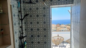 A bathroom with a shower, toilet, and a view of the sea. - House with 2 terraces and sea view. 2 Bedrooms, 500m from the Beach. (Puerto de Mazarrón)