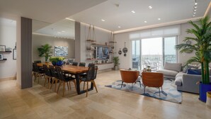 A spacious living area with a dining table, sofas, and a balcony with a city view. - Gorgeous 2BR Marina View Retreat (Río Hato)