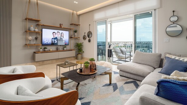A modern living room with a flat-screen TV, comfortable seating, a balcony with a view, and a large window. - Gorgeous 2BR Marina View Retreat (Río Hato)