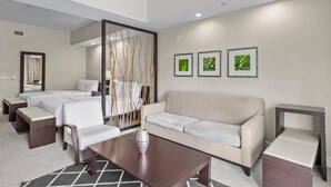 A hotel room with a bed, a sofa, a coffee table, and a decorative wall panel. - Stay & Play 4 Major Golf Courses (Miami)