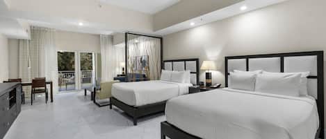 Une chambre d’hôtel avec deux lits, un coin repas et un balcon avec des rideaux.
