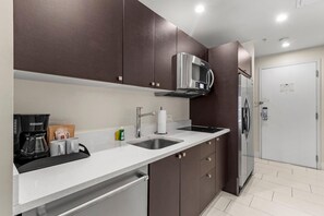 A modern kitchen with stainless steel appliances, a coffee maker, and a microwave.