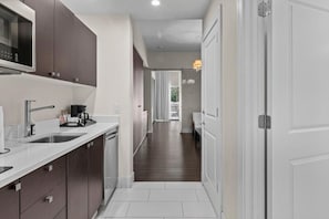 A modern kitchen with a microwave, sink, and cabinets.