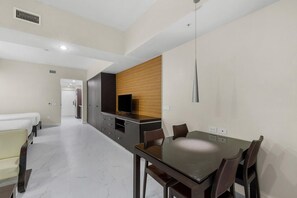 A hotel room with a dining area, a TV, and a wooden accent wall. - Poolside, Refresh, Relax, & Reconnect (Miami)