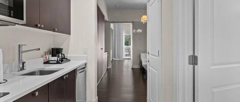 A modern kitchen with a microwave, sink, and cabinets.