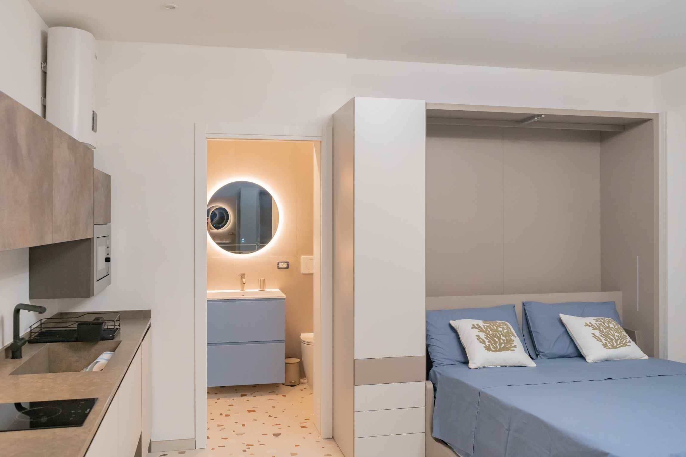 Un dormitorio moderno con cama, mesita de noche y armario.