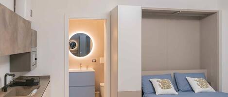 Un dormitorio moderno con cama, mesita de noche y armario.